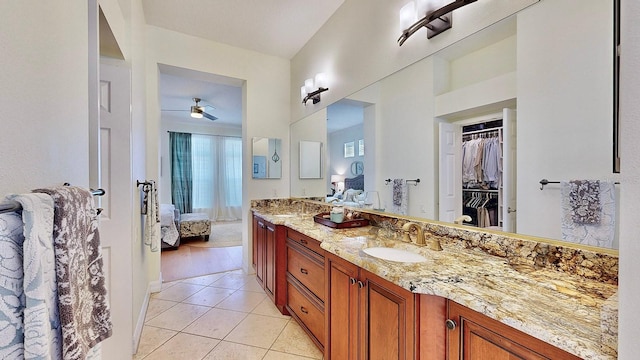 ensuite bathroom with connected bathroom, ceiling fan, tile patterned floors, a walk in closet, and vanity