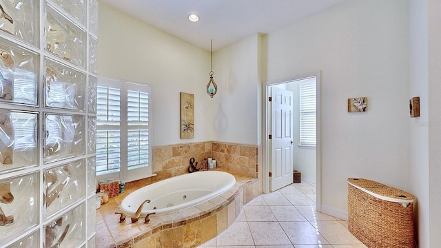 full bath featuring a tub with jets, tile patterned flooring, and baseboards