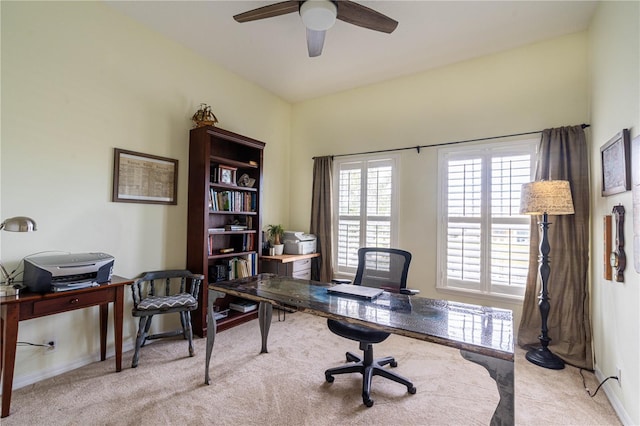 office featuring light carpet, ceiling fan, and baseboards