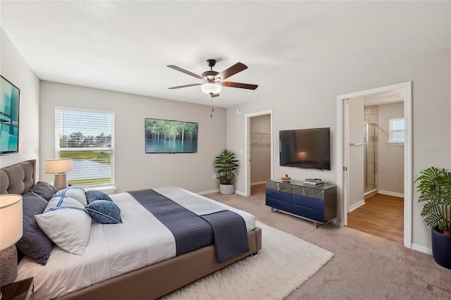 bedroom featuring carpet floors, a closet, a walk in closet, and baseboards