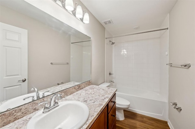 bathroom with bathing tub / shower combination, visible vents, toilet, vanity, and wood finished floors