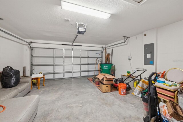 garage featuring a garage door opener, concrete block wall, and electric panel