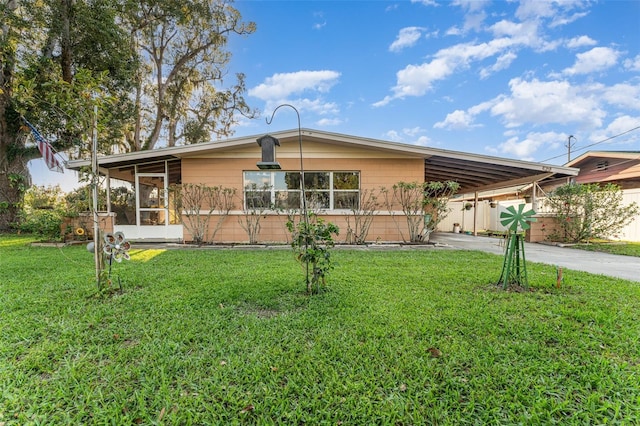 view of front facade with driveway, a sunroom, an attached carport, and a front yard