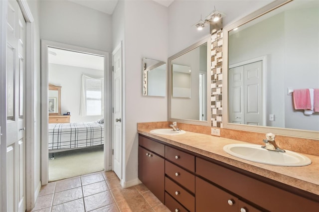 full bath featuring ensuite bathroom, double vanity, a sink, and tile patterned floors