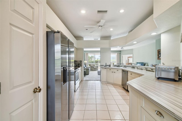 kitchen with light tile patterned floors, stainless steel appliances, visible vents, a ceiling fan, and open floor plan