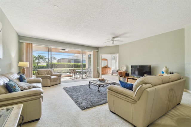 carpeted living room with a textured ceiling, a sunroom, and a ceiling fan