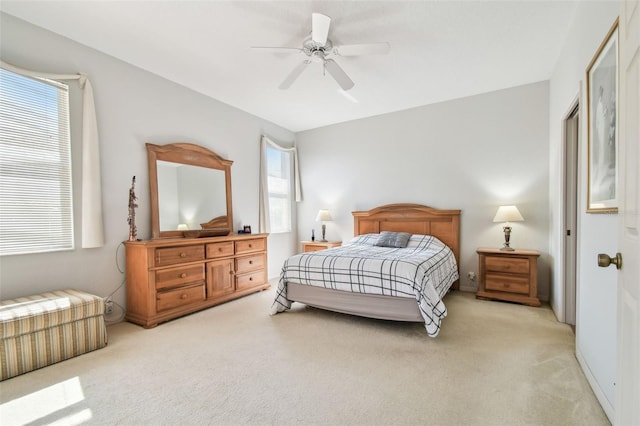 bedroom featuring light carpet and a ceiling fan