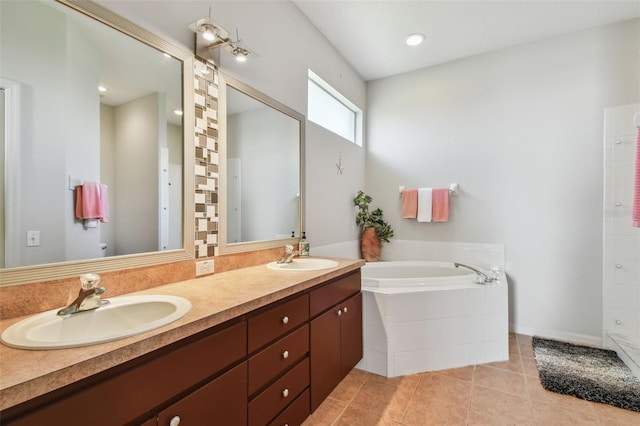 full bathroom featuring a garden tub, double vanity, tile patterned flooring, and a sink