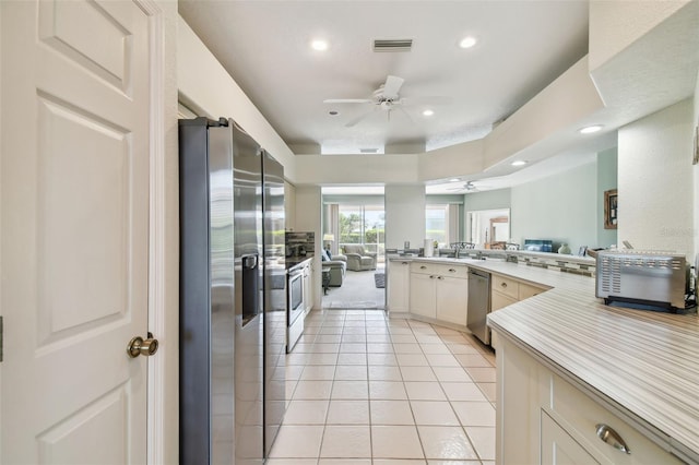 kitchen with appliances with stainless steel finishes, open floor plan, light tile patterned floors, visible vents, and ceiling fan
