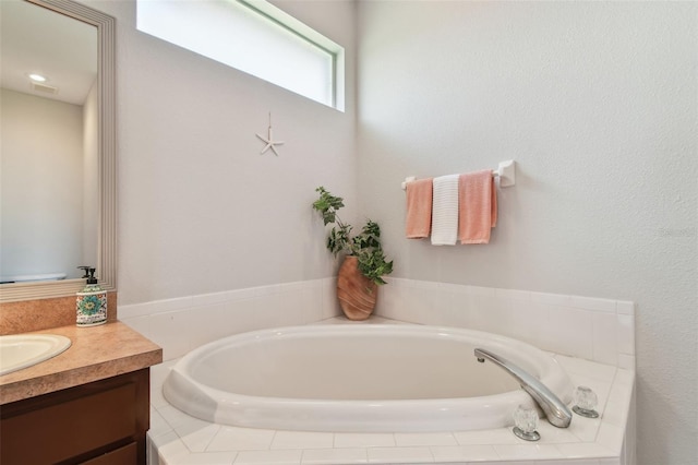 bathroom with a garden tub and vanity