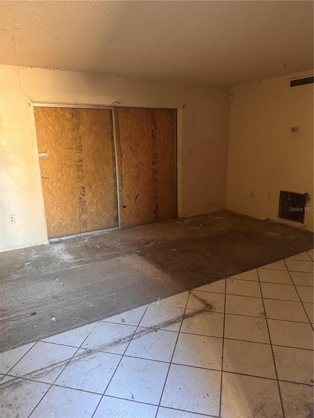 unfurnished room with visible vents and a textured ceiling