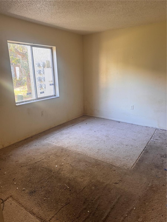 unfurnished room with a textured ceiling