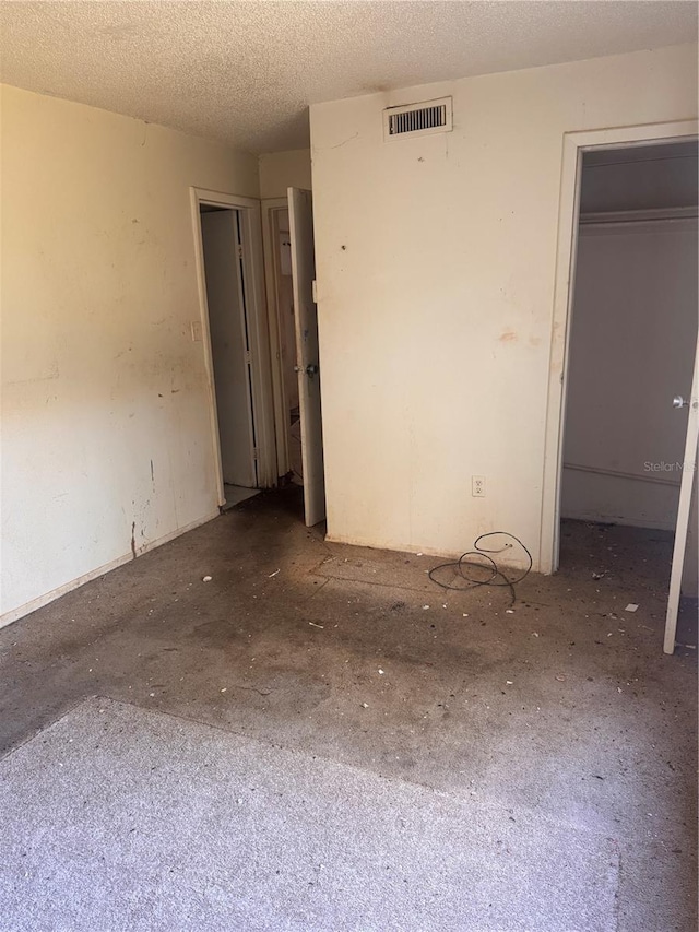 empty room featuring visible vents and a textured ceiling