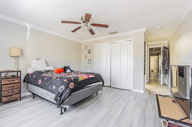 bedroom featuring visible vents, baseboards, ornamental molding, a closet, and light wood-type flooring