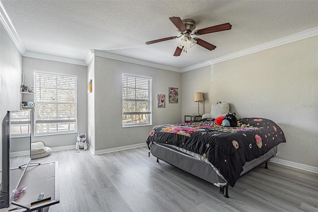 bedroom with baseboards, multiple windows, wood finished floors, and crown molding