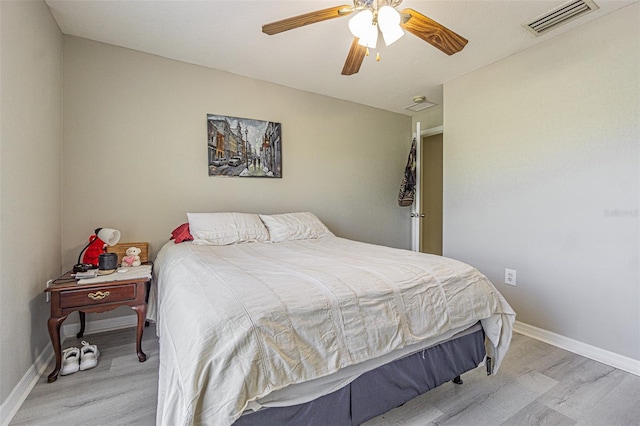 bedroom with baseboards, visible vents, ceiling fan, and light wood finished floors