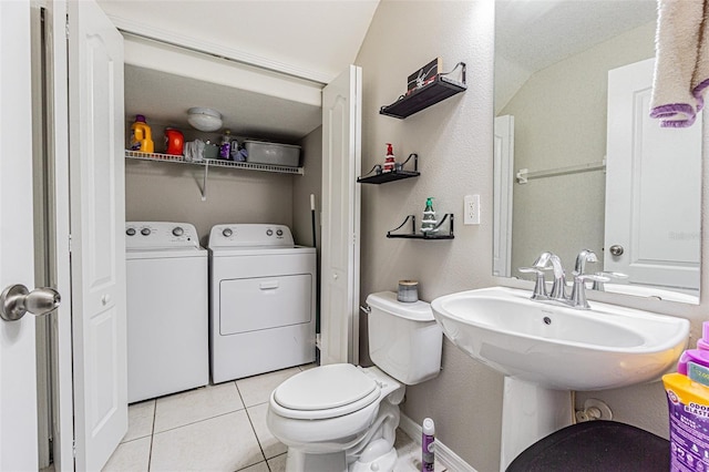 bathroom featuring washer and clothes dryer, tile patterned flooring, toilet, and baseboards