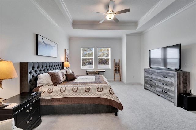 bedroom with a tray ceiling, light colored carpet, and crown molding