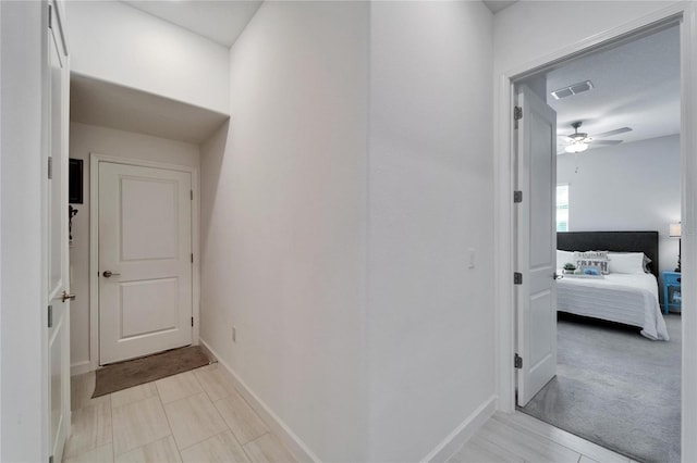 corridor featuring visible vents and baseboards