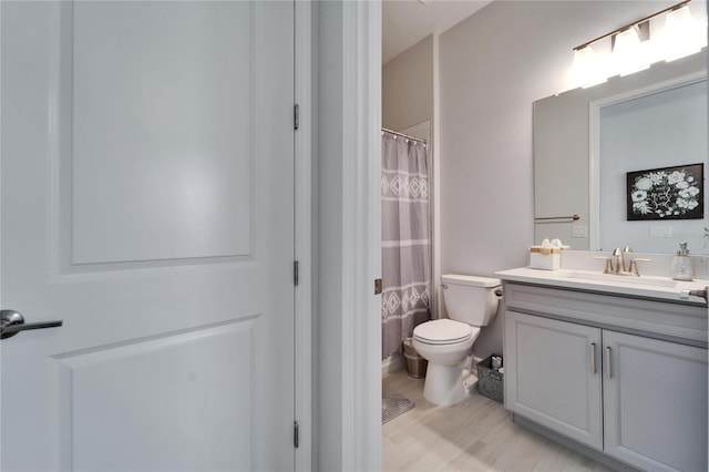 full bath featuring a shower with curtain, vanity, and toilet