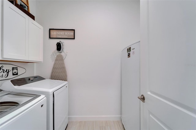 laundry room with independent washer and dryer, cabinet space, and baseboards