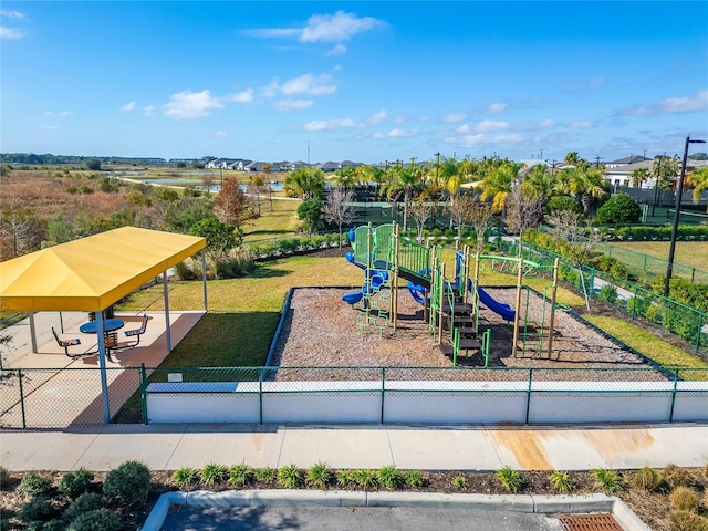 community jungle gym with fence and a lawn