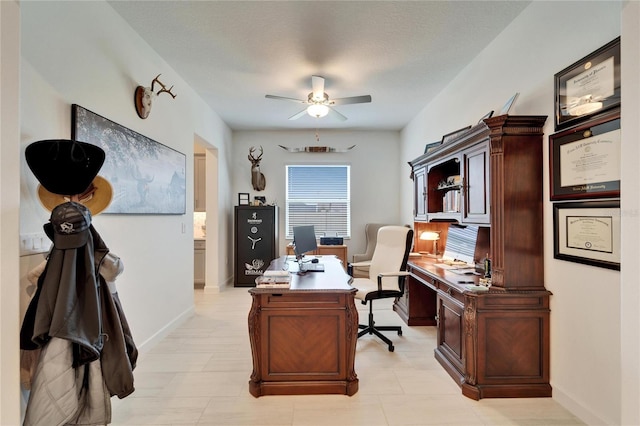 office area featuring a ceiling fan and baseboards
