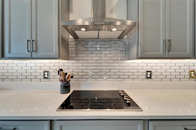 kitchen featuring light countertops, island exhaust hood, decorative backsplash, and black electric cooktop