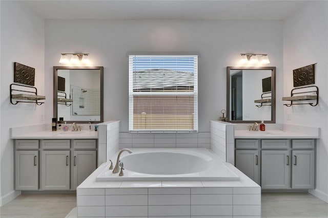 full bath featuring a garden tub, two vanities, a sink, and tiled shower