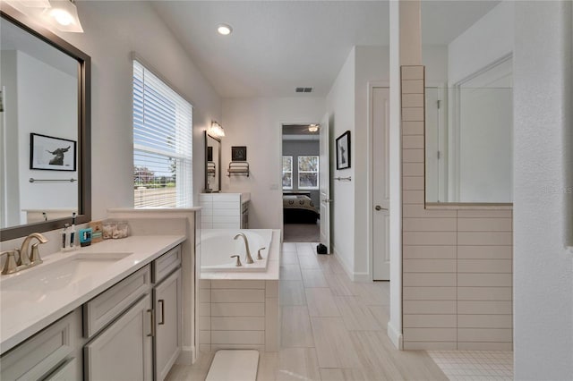 full bath featuring connected bathroom, visible vents, plenty of natural light, and a garden tub