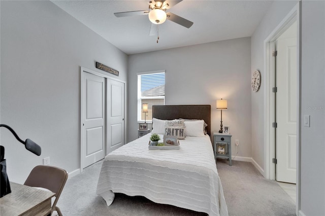 bedroom featuring light carpet, a ceiling fan, baseboards, and a closet