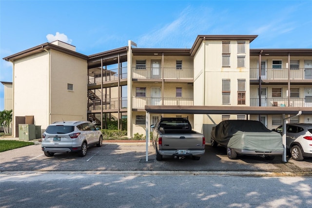 view of property featuring covered and uncovered parking