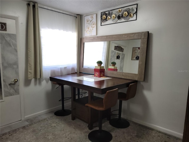 dining area with a textured ceiling and baseboards