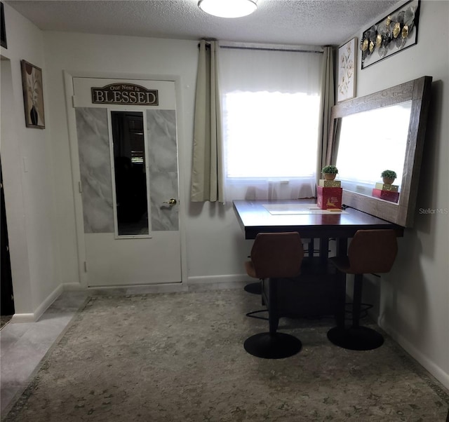 dining area with baseboards and a textured ceiling