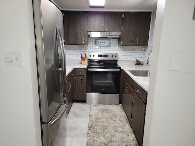 kitchen with under cabinet range hood, tasteful backsplash, stainless steel appliances, and dark brown cabinets