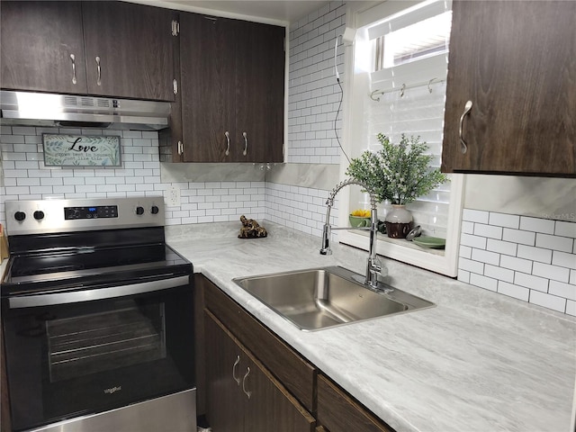 kitchen featuring under cabinet range hood, a sink, light countertops, decorative backsplash, and stainless steel range with electric stovetop