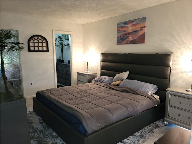 bedroom featuring a textured ceiling, a spacious closet, and a closet