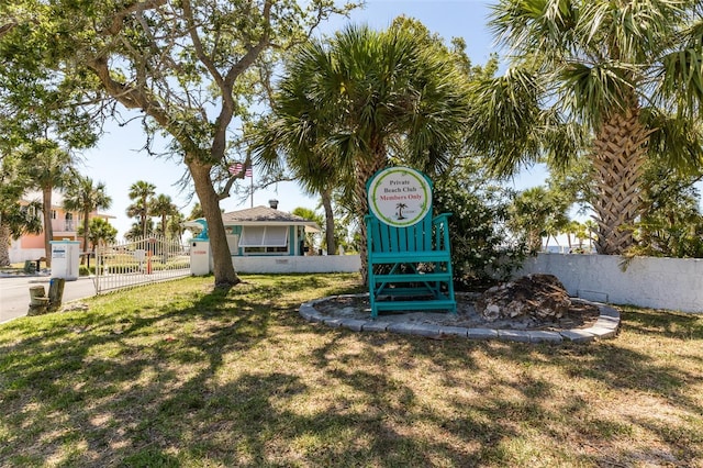 view of community with fence and a lawn