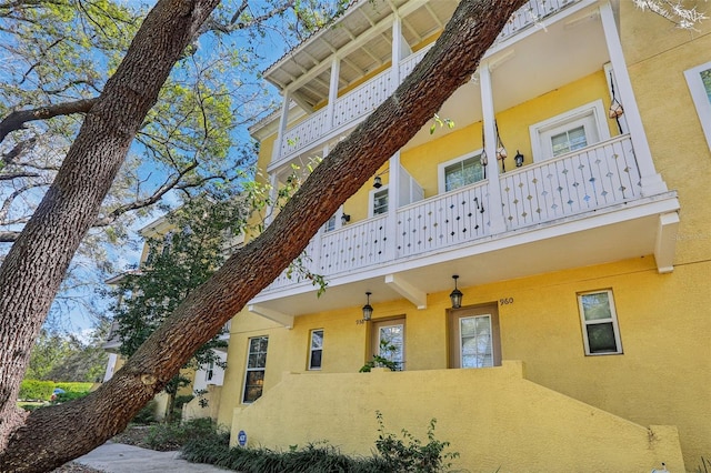 view of side of property featuring a balcony and stucco siding