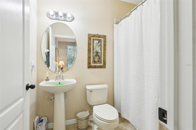 full bath featuring toilet and baseboards