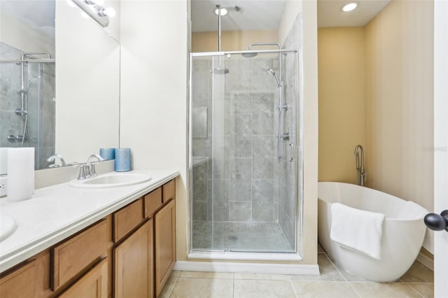 bathroom with double vanity, a stall shower, tile patterned flooring, and a sink