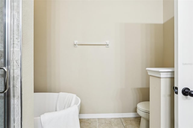 bathroom with baseboards, a shower stall, toilet, and tile patterned floors