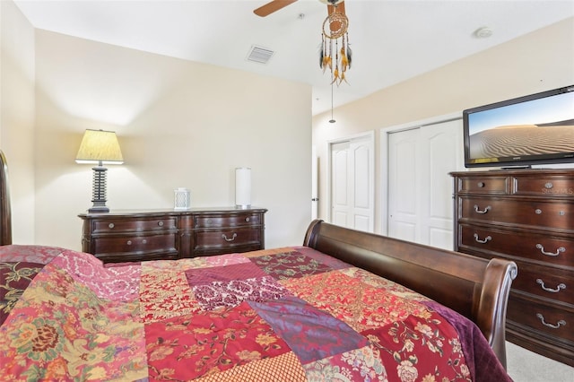 carpeted bedroom featuring ceiling fan, two closets, and visible vents