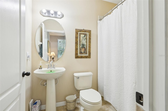 full bath featuring toilet, baseboards, and tile patterned flooring