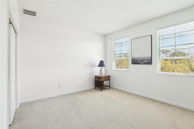 unfurnished bedroom featuring baseboards, visible vents, and carpet floors