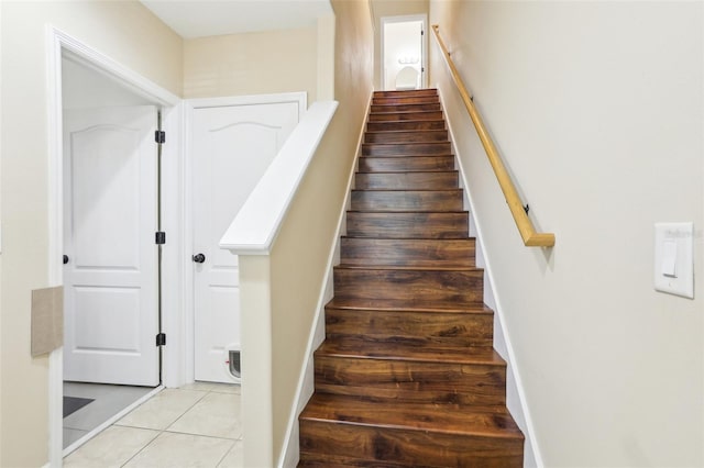 stairway with tile patterned floors and baseboards