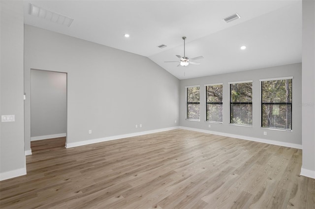 empty room featuring light wood-style flooring, visible vents, vaulted ceiling, and a ceiling fan