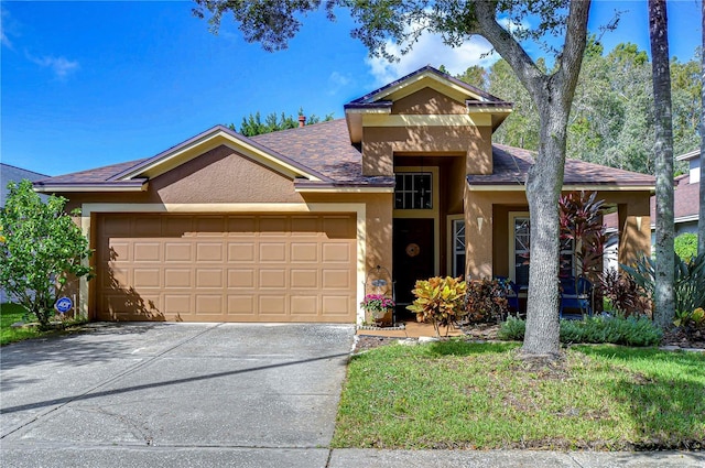 view of front of property featuring concrete driveway, an attached garage, and stucco siding