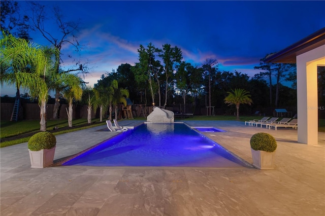 pool at dusk featuring a patio area, a fenced backyard, and a fenced in pool