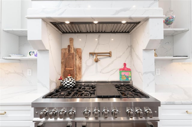 kitchen with open shelves, high end stainless steel range, decorative backsplash, white cabinetry, and exhaust hood